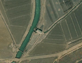 4/4 Pumping station (man_made=pumping_station) connecting a watercourse to the canal system (Maxar satellite imagery).