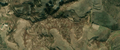 7/8 Cimetière désordonné (landuse=cemetery), sans structure sur des reliefs vallonnés (imagerie satellite Maxar).
